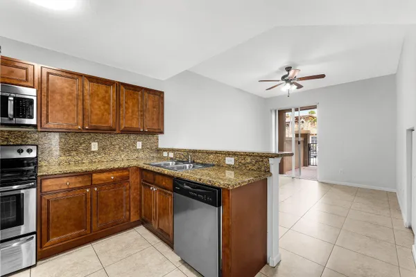 a kitchen with stainless steel appliances granite countertop a sink and dishwasher a stove top oven with wooden floor