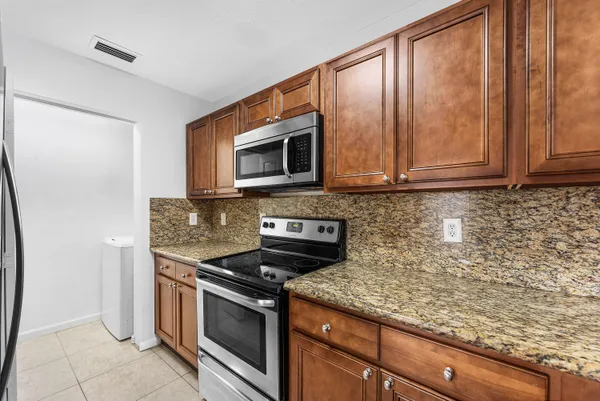 a kitchen with stainless steel appliances granite countertop a stove a microwave and a sink