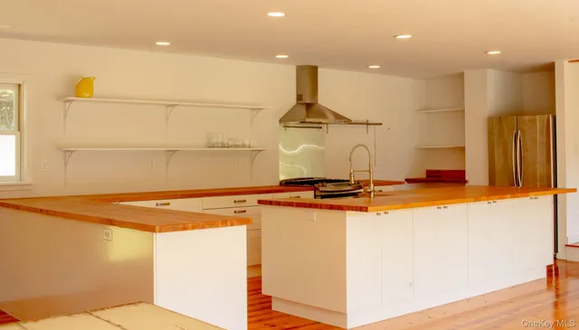 a room with stainless steel appliances a sink and a refrigerator