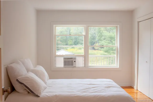 a bedroom with a bed and a large window