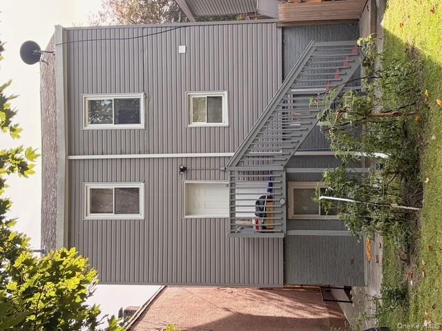 42 Hasbrouck Street Newburgh, NY 12550 - Photo 4 of 24 Back of property with stairway, brick siding, and a patio area