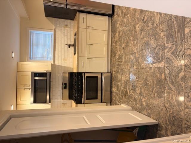42 Hasbrouck Street Newburgh, NY 12550 - Photo 8 of 24 Kitchen with white cabinetry, stainless steel range with gas cooktop, backsplash, refrigerator, and recessed lighting