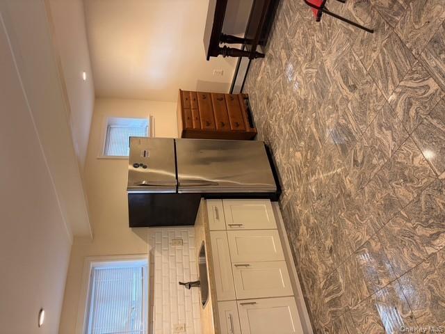 42 Hasbrouck Street Newburgh, NY 12550 - Photo 10 of 24 Kitchen featuring backsplash, freestanding refrigerator, white cabinets, recessed lighting, and a baseboard radiator