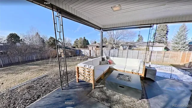 a view of a patio with a table and chairs under an umbrella