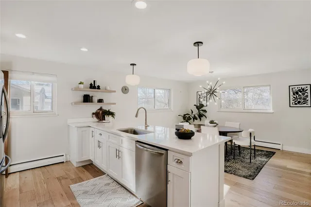 a kitchen with a sink dishwasher and a stove with wooden floor