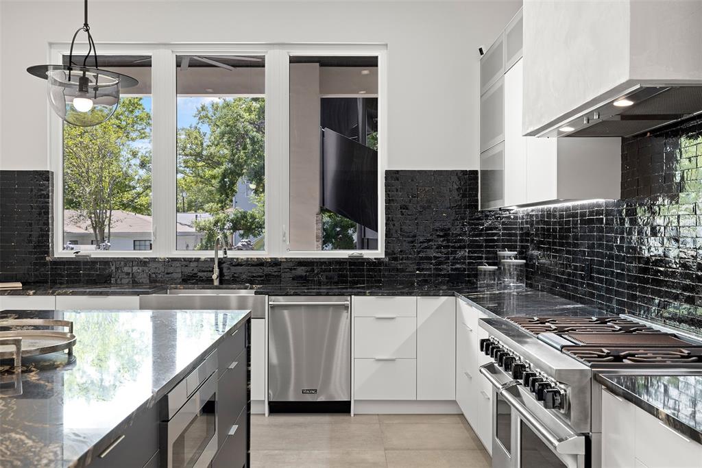4924 West San Rafael Street Tampa, FL 33629 - Photo 19 of 64 a kitchen with granite countertop a sink a stove a washer and dryer