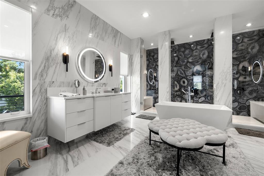 4924 West San Rafael Street Tampa, FL 33629 - Photo 46 of 64 a bathroom with a granite countertop sink a toilet a mirror and a tub