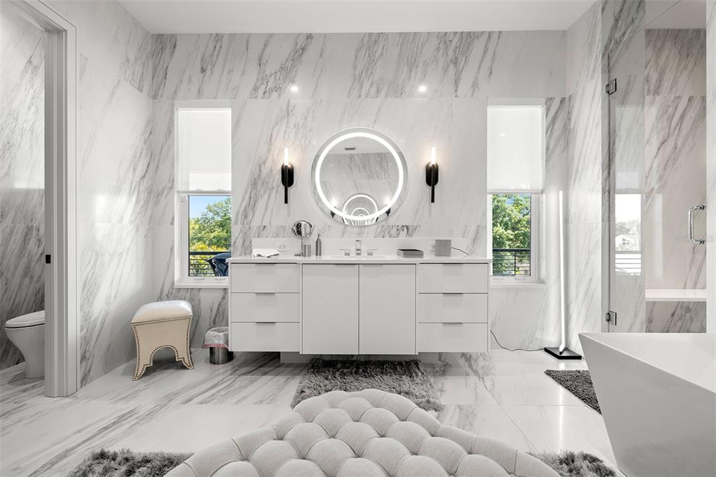 4924 West San Rafael Street Tampa, FL 33629 - Photo 57 of 64 a bathroom with a sink mirror and a bathtub next to a window