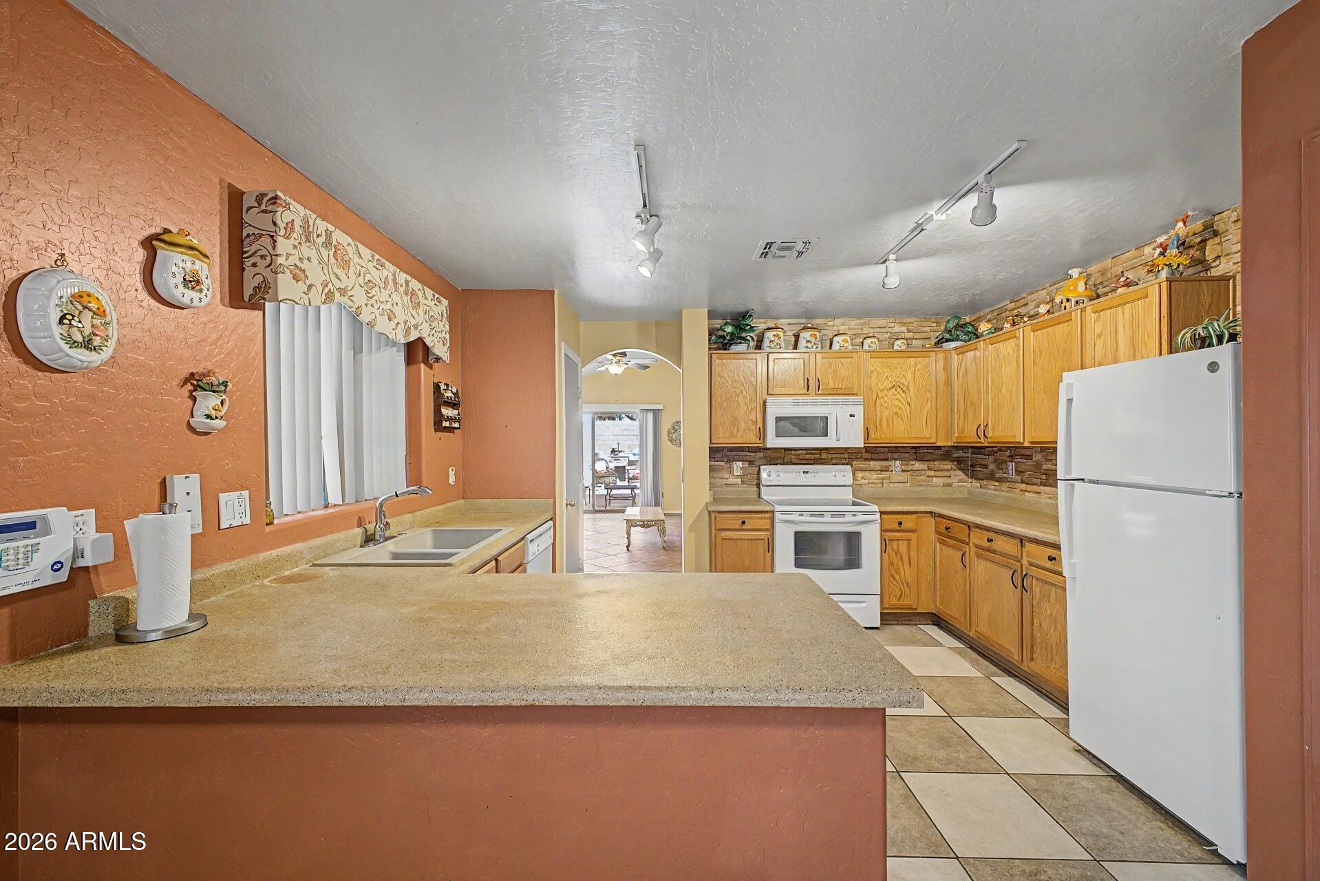 3691 South Conestoga Road Apache Junction, AZ 85119 - Photo 11 of 31 a kitchen with stainless steel appliances granite countertop a sink and refrigerator