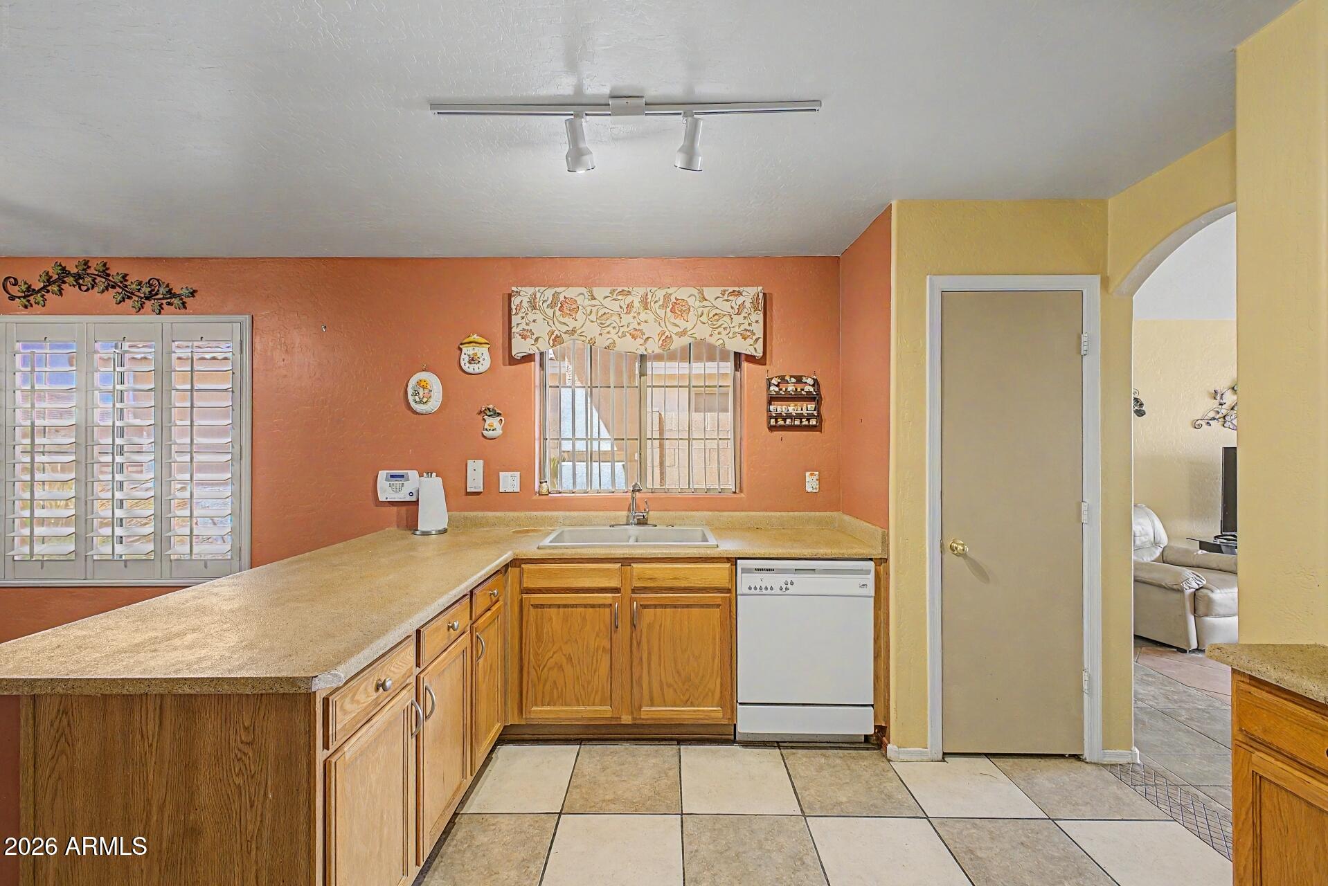 3691 South Conestoga Road Apache Junction, AZ 85119 - Photo 12 of 31 a kitchen with a sink a stove a refrigerator and white cabinets