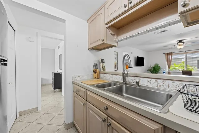 a kitchen with stainless steel appliances granite countertop a sink and a refrigerator