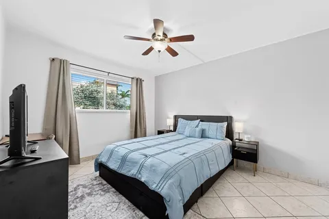 a bedroom with a bed and a flat tv screen on the dresser