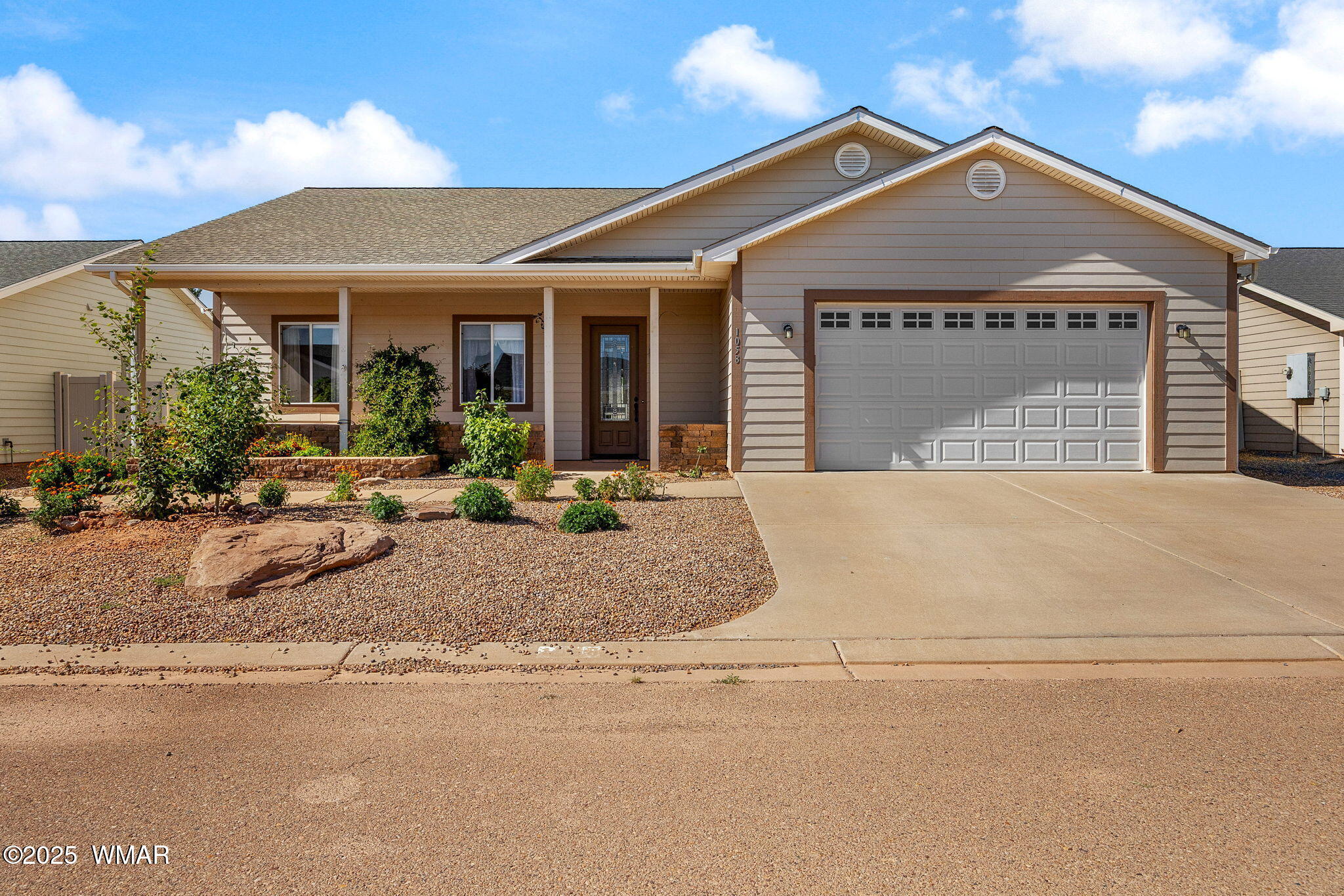 a front view of a house with a garden and patio