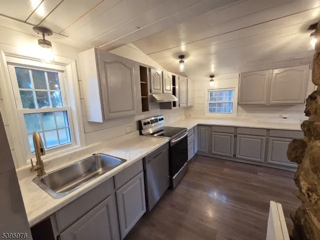 a kitchen with a sink stove top oven and cabinets