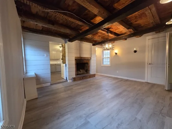 a view of empty room with wooden floor and fireplace