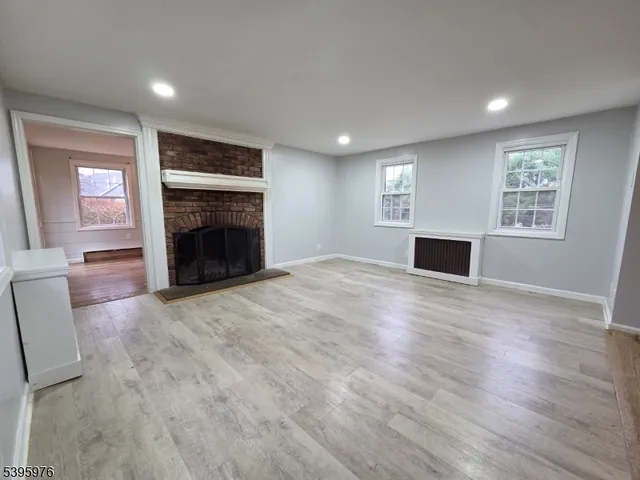 an empty room with windows fireplace and a sink