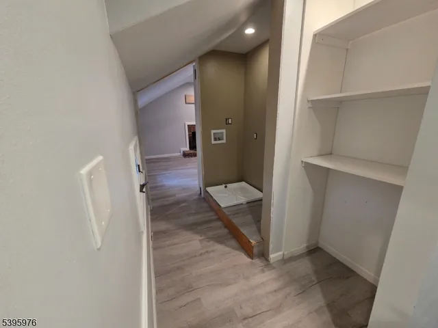 view of a hallway with wooden floor and a living room