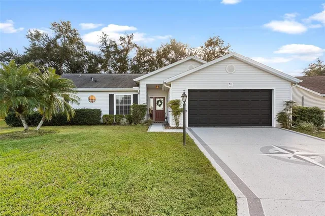 a front view of house with yard and trees in the background