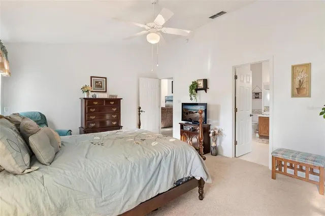 a bedroom with a large bed and a chandelier