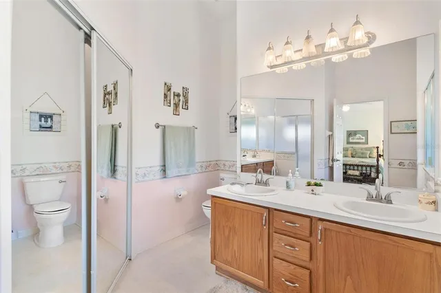 a bathroom with a double vanity sink mirror and toilet