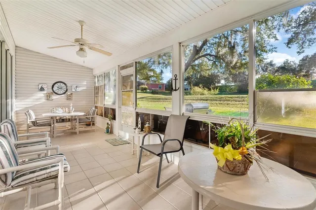 a living room with patio furniture and a floor to ceiling window