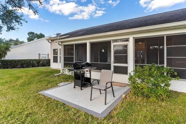 a view of a house with backyard sitting area and garden