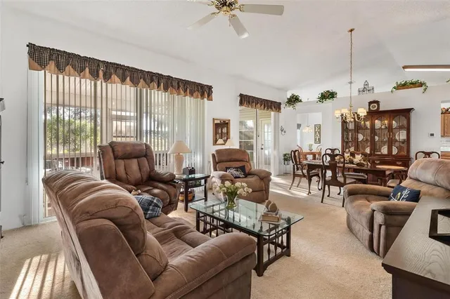 a living room with furniture ceiling fan and a window