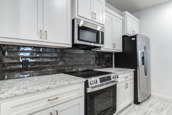 a kitchen with granite countertop cabinets and steel stainless steel appliances