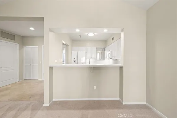 a view of kitchen with refrigerator and window