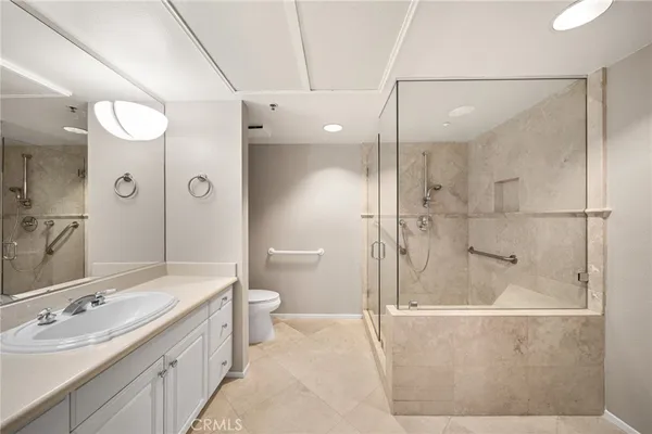 a bathroom with a double vanity sink toilet mirror and shower