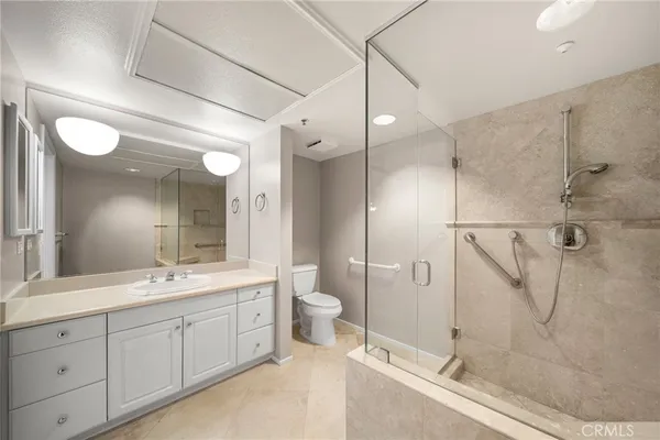 a spacious bathroom with a double vanity sink toilet mirror and shower
