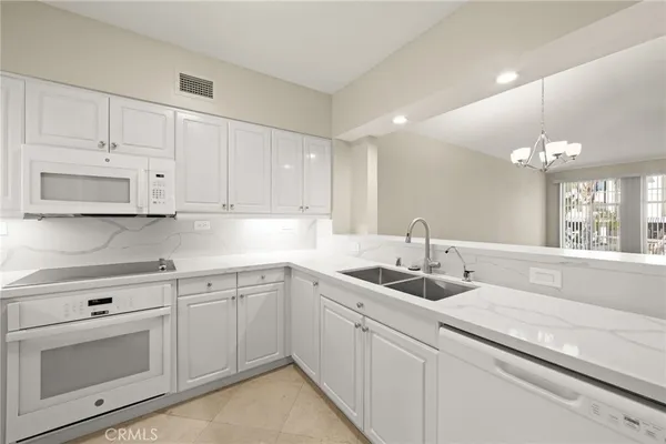 a white kitchen with cabinets and sink