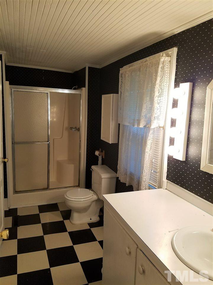 25 Oak Street Roxboro, NC 27573 - Photo 8 of 14 a bathroom with a sink a toilet a shower and a mirror