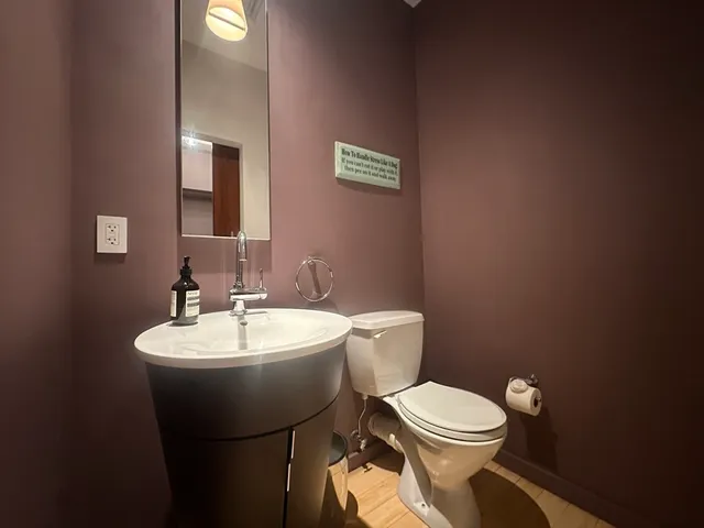 a bathroom with a toilet a sink and mirror