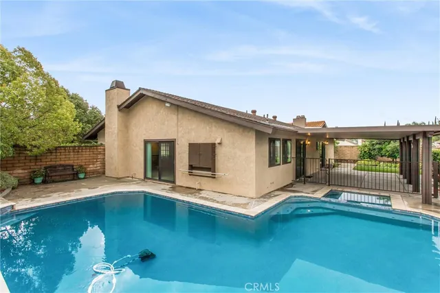 a view of house with swimming pool outdoor seating