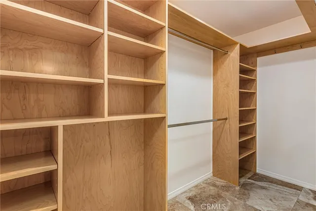 a view of walk in closet with empty racks