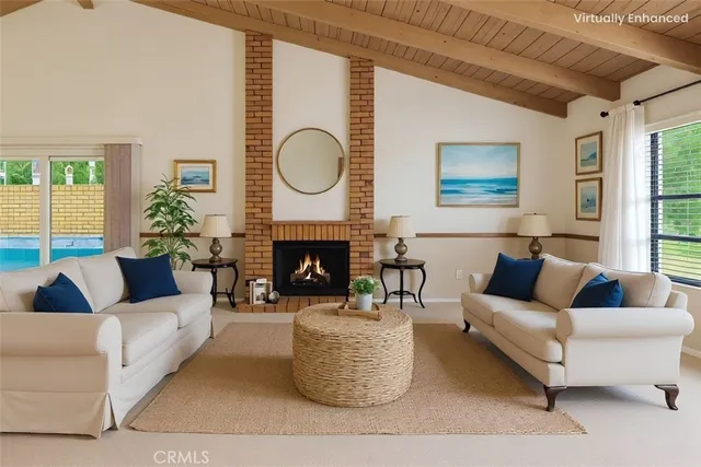 a living room with furniture a fireplace and a large window