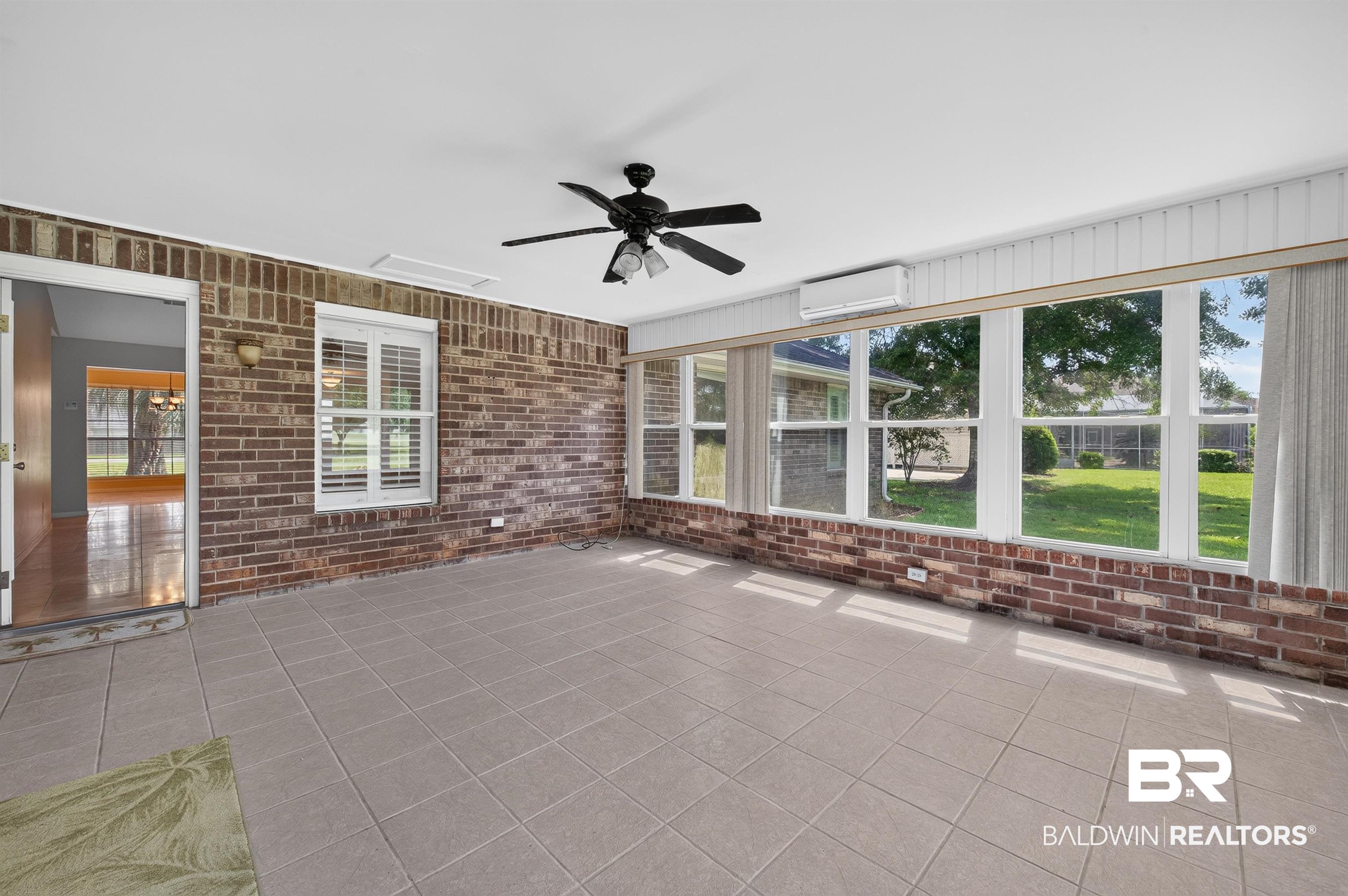 22685 County Road 12 Foley, AL 36535 - Photo 73 of 89 Sunroom featuring brick accent walls, extensive window panels, and neutral-toned tile flooring