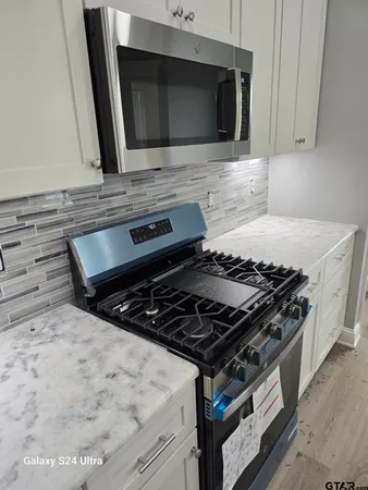 a stove top oven sitting inside of a kitchen