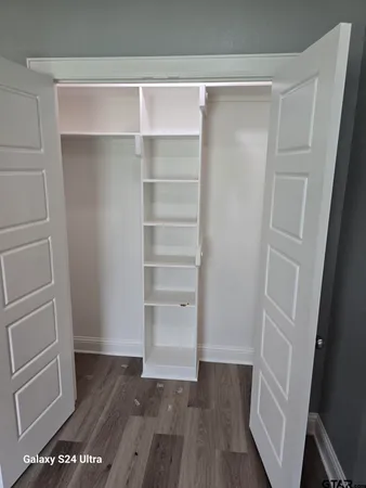 a view of walk in closet with empty racks