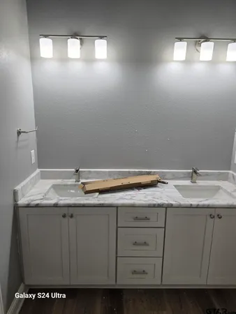 a bathroom with a granite countertop sink and a mirror