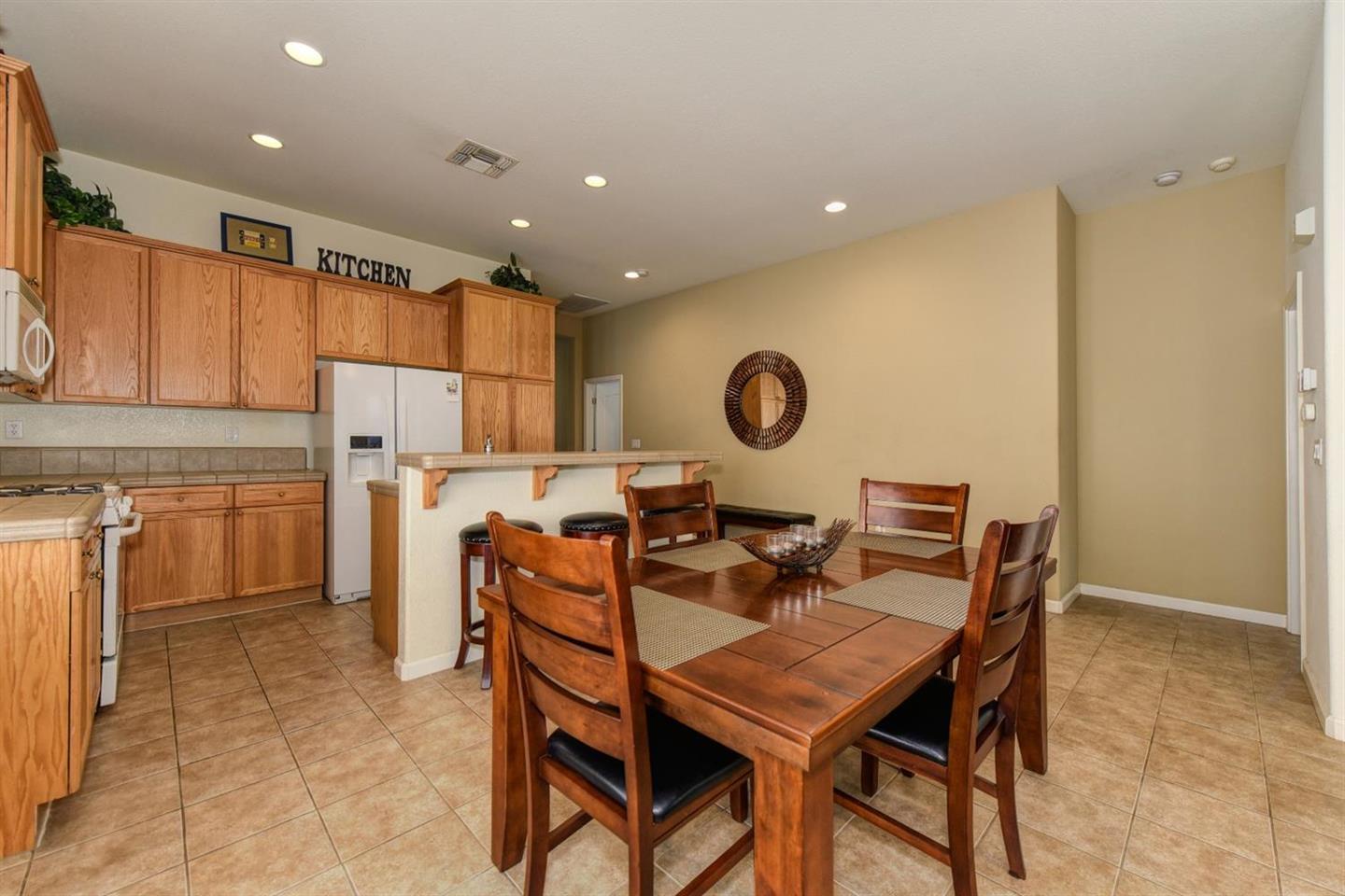 3557 Rainsong Circle Rancho Cordova, CA 95670 - Photo 11 of 27 a view of a dining room that has a dining table and chairs with wooden floor