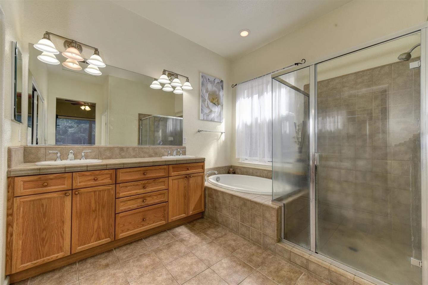 3557 Rainsong Circle Rancho Cordova, CA 95670 - Photo 17 of 27 a spacious bathroom with a double vanity sink mirror and shower