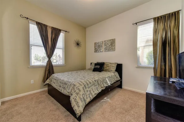 a bedroom with a bed window and mirror