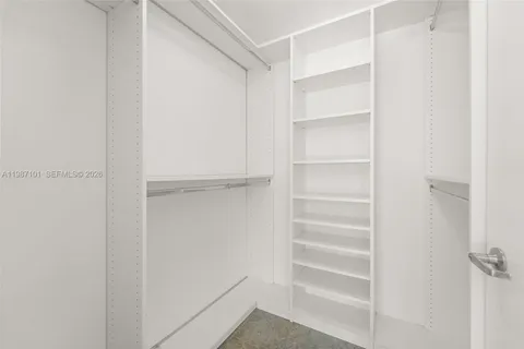 a view of walk in closet with empty racks
