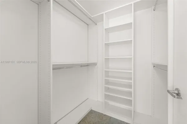 a view of walk in closet with empty racks