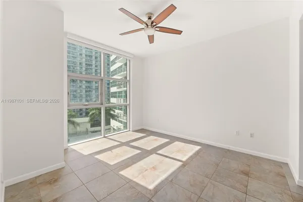 an empty room with windows and fan