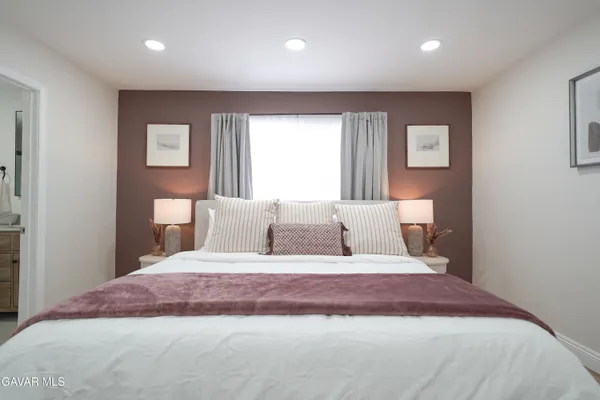 a bedroom with a large bed and a flat screen tv