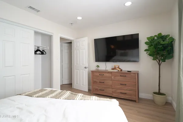 a bedroom with a bed and a potted plant