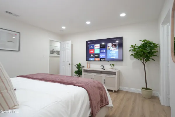 a living room with furniture a wooden floor and a flat screen tv